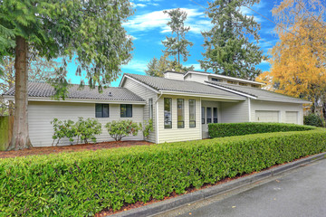 Nicely remodeled home exterior with boxwood hedge
