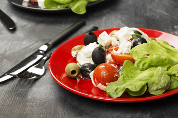 Greek salad feta, cherry tomatoes, olives, cucumbers on a dark background