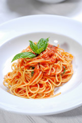 plate of delicious spaghetti with sauce and fresh basil