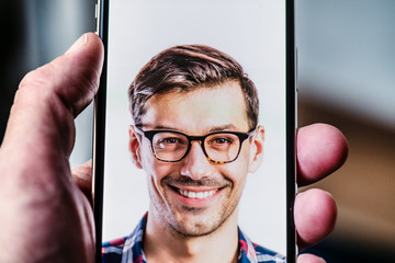 A smartphone using face ID recognition system.