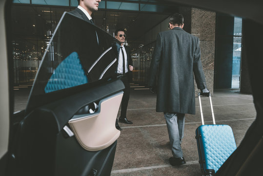 businessman going with blue bag on wheels to airport