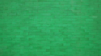 Backsteinmauer mit grünen Steinen
