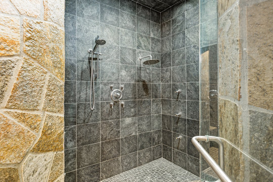 Luxurious mansion walk-in shower with black square tiled walls