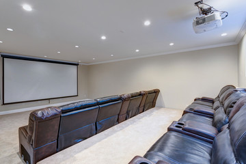 Contemporary basement movie room with black leather chairs