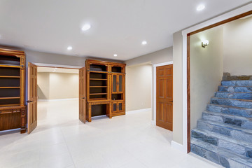 Spacious empty basement area with custom built bookcases.