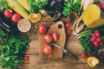Vegetables on wooden background. Herbs, basil, onion, pumpkin, pine nuts, tomatoes, corn, radish,...