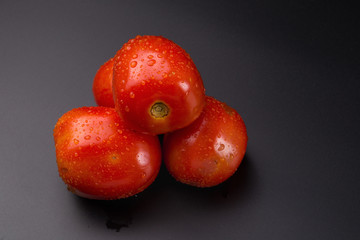 Ripe red tomatoes isolated on black background