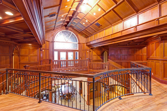 Second floor landing accented with wood paneled walls and ceiling.