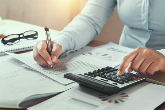 businesswoman working in office on desk using calculator and pen
