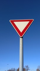 give way traffic sign on a blue sky background