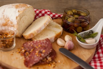 Close up of meat and bread by olives in container