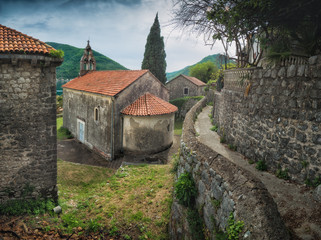 Old stone churche on a small street of Perast