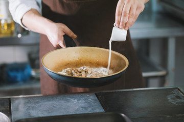 Chef is pouring the sauce into the meat