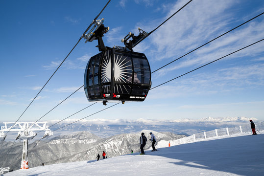 Skiers on the slope. Cableway Funitel in Low Tatras mountains, Slovakia.