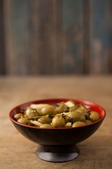 Close up of green olives in red bowl