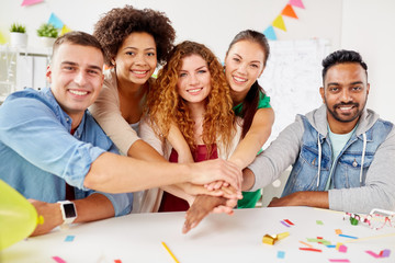 happy business team at office party holding hands