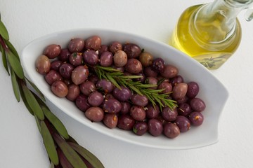 Overhead view of olives and rosemary with oil in jar