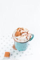 Christmas mood!) Hot chocolate with cream, cinnamon and a toffee in a blue vintage mug on a light background. The best celebration background. Winter xmas holidays concept.