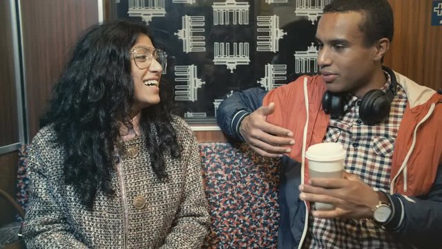Middle Eastern woman and an African man traveling on a train in Berlin underground and talking