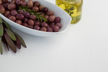 Close up of olives and rosemary with oil in jar