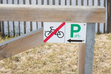 billboard indicates that it is forbidden to park your bike here and that the car park is on the side