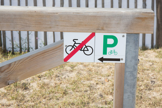 Billboard Indicates That It Is Forbidden To Park Your Bike Here And That The Car Park Is On The Side