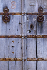 wooden door entrance with metal features.metal rounded hinge on old timber door. stone building with plank door. rusty nails on wood