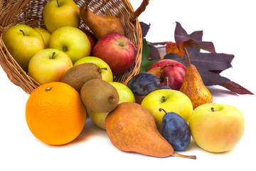 apples and other fruits in a wicker basket on a white background