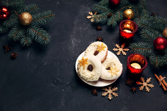 Christmas Chocolate donuts on dark festive background with candles