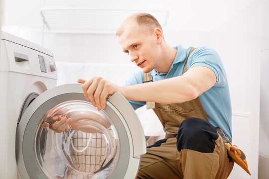 Handyman fixing washing machine