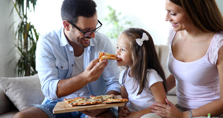 Happy family sharing pizza together at home
