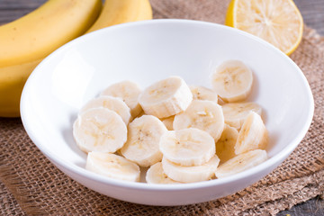 Slices of banana in a white bowl on the table
