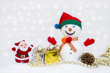 Christmas concept background, Santa Clause and snow man with silver and gold gift box over blurred bokeh on white background