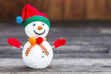 Cute snow man over blurred wood background, Christmas concept background