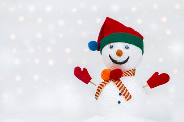 Design handmade snow man on white snow over blurred light bokeh on white background
