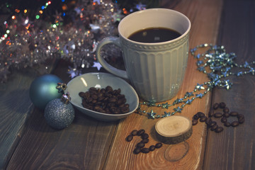 Fototapeta na wymiar A romantic festive still life with a blue cup of freshly brewed coffee, glitter blue decorations,a blue plate with coffee beans and 2018 inscription of coffee beans and a wooden circle. Colored wooden