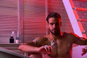 Obraz premium Guy meditating in bathroom with toiletries and stairs on background
