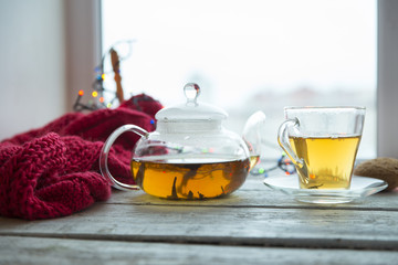 Cup of coffee or tea, smartphone and earbuds with autumn leaves near a window. Autumn playlist concept. Autumn music for rainy days.