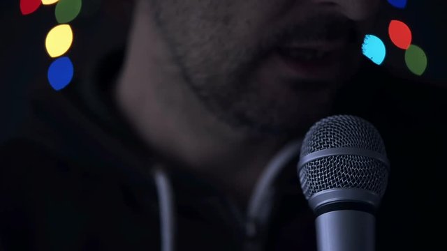 Man sings karaoke in a bar at night with festive bokeh light effect