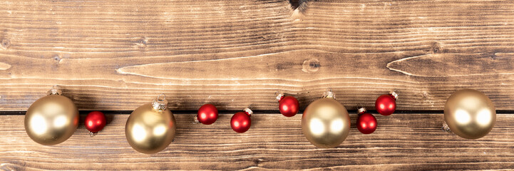 Naklejka na ściany i meble red and gold christmas balls on a wooden background panorama