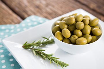 Marinated olives with rosemary on tray