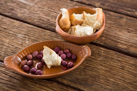 Marinated olives and bread pieces in bowl