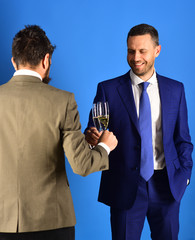 Managers with beards hold glasses of champagne.