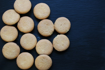 A lot of round biscuits on a black background.