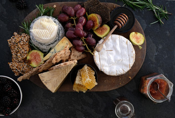 Seasonal cheese platter, with a variety of cheeses, fruit, honey, crackers and sprigs of rosemary. 