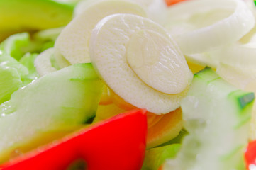 Close up of fresh salad with vegetables, tomato, onion, palmito, avocado and cucumbers, healthy food
