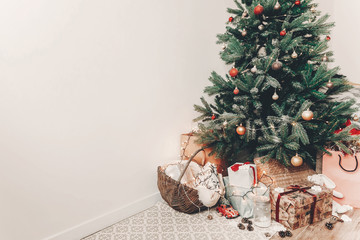 merry christmas and happy new year concept. festive room with christmas tree with lights, space for text. gifts and presents under tree. happy holidays
