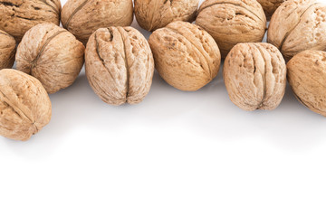 Walnuts in pile on white background with copy space