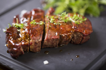 Grilled Beef Steak with sous herbs on a black plate