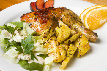 Chicken with potatoes  chips and salad on a white plate